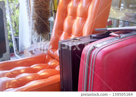 Retro luggage and vintage armchair create a vibrant, nostalgic scene Retro luggage and vintage armchair create a vibrant, nostalgic scene 139505164