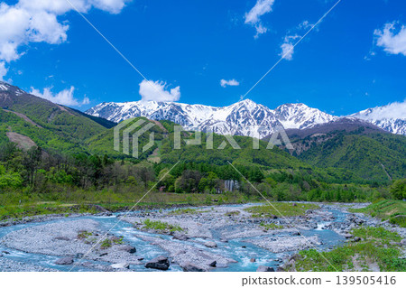 [Early Summer Scenery] Mountainous landscape of Hakuba Village with fresh green leaves, as seen from Hakuba Ohashi Bridge [Nagano Prefecture] 139505416