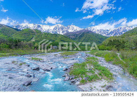 [Early Summer Scenery] Mountainous landscape of Hakuba Village with fresh green leaves, as seen from Hakuba Ohashi Bridge [Nagano Prefecture] 139505424