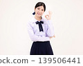 Cheerful Asian high school student girl in Thai school uniform showing OK sign gesture with hand, smiling happily, isolated on white background. 139506441