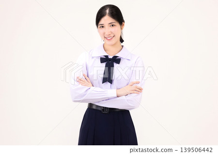 Confident Asian high school student girl in Thai school uniform standing with arms crossed, smiling at camera, isolated on white background. Confident Asian high school student girl in Thai school uniform standing with arms crossed, smiling at camera, isolated on white background. 139506442