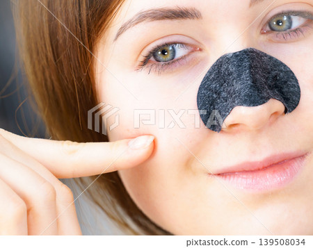 Woman applying pore strips on nose 139508034