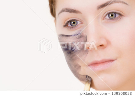 Woman being apply black carbo mask to face Woman being apply black carbo mask to face 139508038