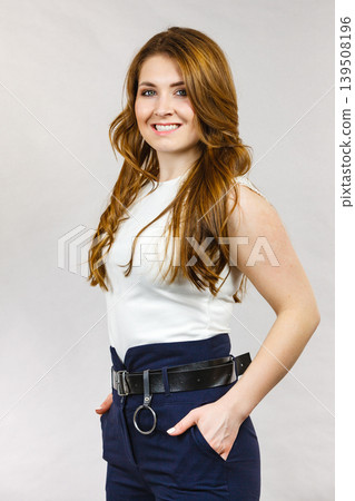 Woman wearing high waist trouser with belt Woman wearing high waist trouser with belt 139508196