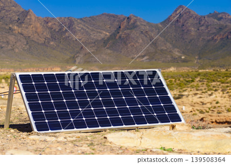 Solar panels in coastal area with mountains in the background during a sunny day Solar panels in coastal area with mountains in the background during a sunny day 139508364