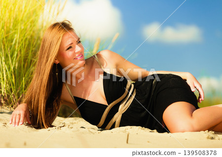 Woman sunbathing on beach. Woman sunbathing on beach. 139508378