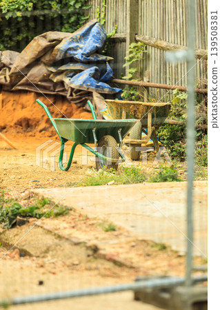 Construction site with green barrow Construction site with green barrow 139508381