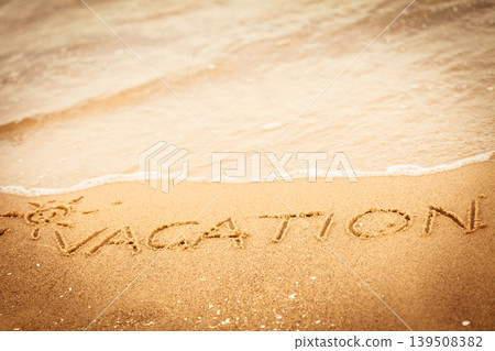 The word vacation written in the sand on a beach The word vacation written in the sand on a beach 139508382