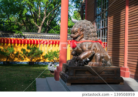 Chinese guardian lion with ribbon by garden at Longhua, Shanghai 139508959