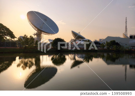 Giant satellite dish antenna station with skyline reflection at sunrise Giant satellite dish antenna station with skyline reflection at sunrise 139508993