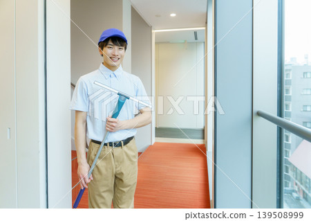 一位年輕男清潔工正在擦窗戶。攝影協助東京電子學院電波學園提供。 139508999