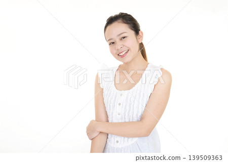 一位面帶微笑的女子,穿著無袖連身裙。 一位面帶微笑的女子,穿著無袖連身裙。 139509363