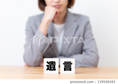A middle-aged woman in a suit is troubled by the idea of blocking her will. A middle-aged woman in a suit is troubled by the idea of blocking her will. 139509383