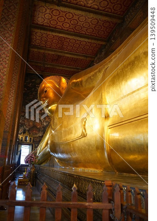 A golden reclining Buddha statue shining with golden light. 139509448