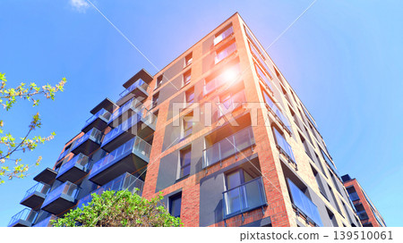 European residential architecture harmonizing with nature. Eco-friendly living in city with greens. Eco apartment building saving energy and fresh air concept.  139510061