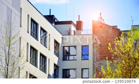 European residential architecture harmonizing with nature. Eco-friendly living in city with greens. Eco apartment building saving energy and fresh air concept. European residential architecture harmonizing with nature. Eco-friendly living in city with greens. Eco apartment building saving energy and fresh air concept. 139510074