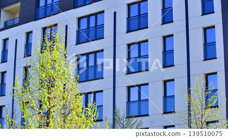 European residential architecture harmonizing with nature. Eco-friendly living in city with greens. Eco apartment building saving energy and fresh air concept. European residential architecture harmonizing with nature. Eco-friendly living in city with greens. Eco apartment building saving energy and fresh air concept. 139510075