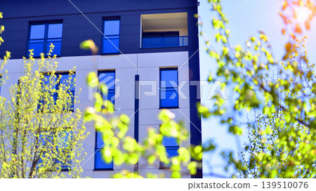 European residential architecture harmonizing with nature. Eco-friendly living in city with greens. Eco apartment building saving energy and fresh air concept. European residential architecture harmonizing with nature. Eco-friendly living in city with greens. Eco apartment building saving energy and fresh air concept. 139510076