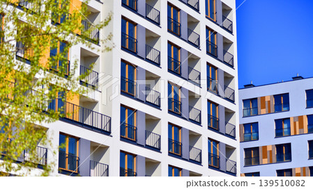European residential architecture harmonizing with nature. Eco-friendly living in city with greens. Eco apartment building saving energy and fresh air concept. European residential architecture harmonizing with nature. Eco-friendly living in city with greens. Eco apartment building saving energy and fresh air concept. 139510082