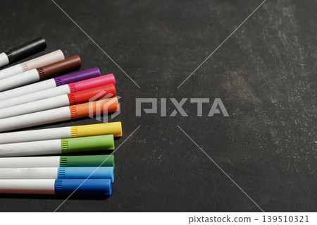Colorful Markers on a Dark Chalkboard Background. Education and Creativity Concept. Classroom and Office Supplies. High quality photo Colorful Markers on a Dark Chalkboard Background. Education and Creativity Concept. Classroom and Office Supplies. High quality photo 139510321