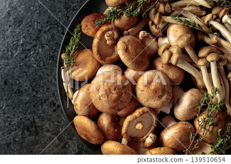 An assortment of mushrooms on a black table. 139510654