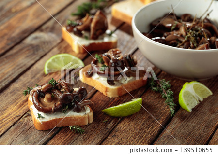 Sandwiches with baked mushrooms on an old wooden table. Sandwiches with baked mushrooms on an old wooden table. 139510655