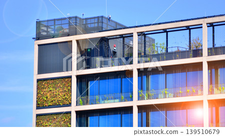 Sustainable glass office building with trees for reducing carbon dioxide. Eco-friendly building in modern city. Office with green environment. Corporate building reduce CO2. 139510679