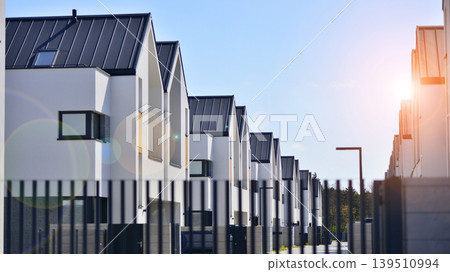 Terraced family homes in newly developed housing estate. The real estate market in the suburbs. New single family houses in a new development area. Residential homes with modern facade. Terraced family homes in newly developed housing estate. The real estate market in the suburbs. New single family houses in a new development area. Residential homes with modern facade. 139510994