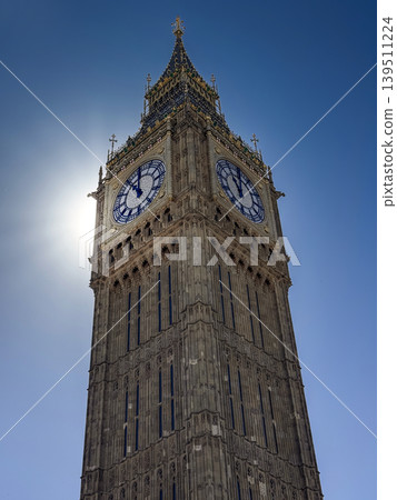 Big Ben Clock Tower in London Against Clear Blue Sky With Sun Backlight and Gothic Detail Big Ben Clock Tower in London Against Clear Blue Sky With Sun Backlight and Gothic Detail 139511224