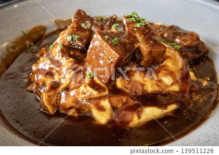 Beef stew with demi-glace sauce served on an omelet 139511226