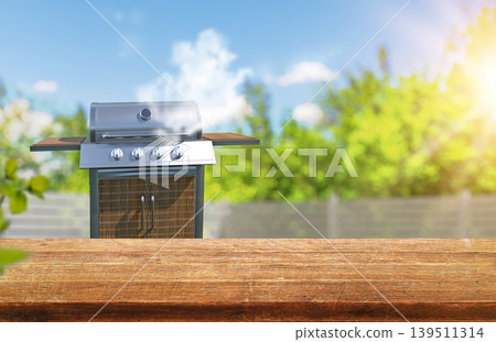 summer time in backyard garden with grill BBQ, wooden table, blurred background summer time in backyard garden with grill BBQ, wooden table, blurred background 139511314
