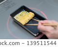 A housewife's hands cooking an omelet 139511544