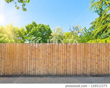 Wooden fence in green garden under blue sky with sun 139511575