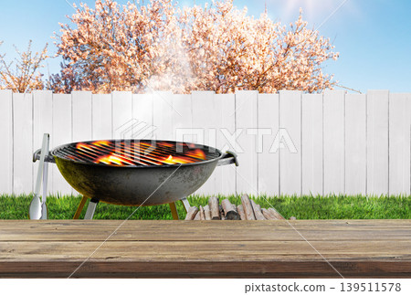 summer time in backyard garden with grill BBQ, wooden table, blurred background summer time in backyard garden with grill BBQ, wooden table, blurred background 139511578