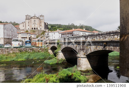 View of the Convento do Carme and the Sar River flowing through Padron under the Santiago bridge on a cloudy day. View of the Convento do Carme and the Sar River flowing through Padron under the Santiago bridge on a cloudy day. 139511908