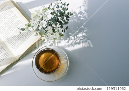 A peaceful tea time with morning light, tea, and white flowers. 139511962