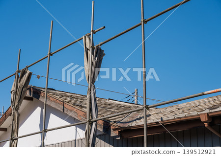 House demolition work: Wooden house with roofing materials removed. House demolition work: Wooden house with roofing materials removed. 139512921