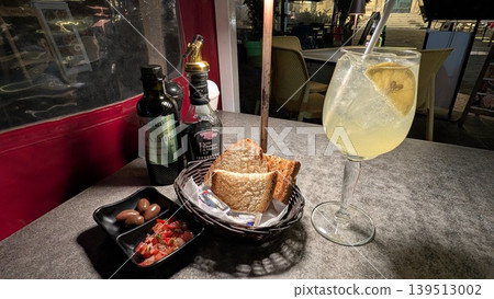 Local limoncello spritz and appetizer toast with fresh tomato salsa and olives 139513002