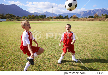 Children, exercise and playing soccer on grass, practice and training for match and game in outdoors. People, kids and fitness or cardio and sports, ball and sportswear or workout together for fun 139513356