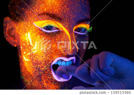 Art, woman with neon face paint and beauty, portrait with bright lipstick and creative skincare on dark background. Orange glow, disco aesthetic and model in studio for creativity with makeup 139513360