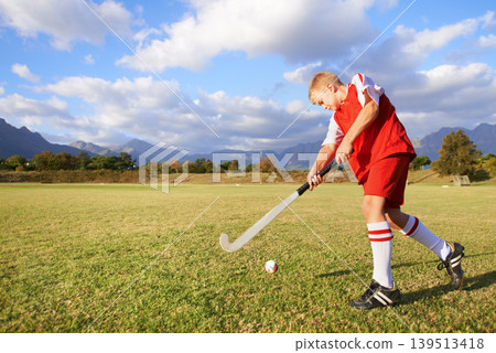 Child, ball and hockey on field for sports, outdoor practice match or game in nature. Young kid or teen player enjoying day on green grass with stick for fitness, activity or training with blue sky Child, ball and hockey on field for sports, outdoor practice match or game in nature. Young kid or teen player enjoying day on green grass with stick for fitness, activity or training with blue sky 139513418