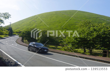 在萬物復甦、綠意盎然的季節，一輛黑色運動型SUV（Mazda）行駛在大室山（伊豆高原）附近的道路上。 139513553
