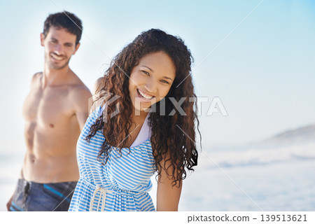 Happy couple, portrait and holding hands on beach for bonding, summer holiday or outdoor weekend together. Man and woman smile on ocean water with blue sky for fun day in the sun on mockup space 139513621