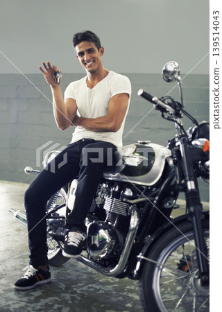 Happy man, portrait and keys sitting on motorcycle keys for transportation or vehicle in garage. Young male person or biker smile for cool automobile, ownership or mechanical motorbike in parking lot Happy man, portrait and keys sitting on motorcycle keys for transportation or vehicle in garage. Young male person or biker smile for cool automobile, ownership or mechanical motorbike in parking lot 139514043