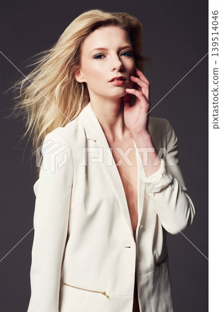 Woman, hand on face and corporate clothes for fashion, beauty and wellness with confident model on dark background. Business jacket, ambition and power in portrait with professional style in studio Woman, hand on face and corporate clothes for fashion, beauty and wellness with confident model on dark background. Business jacket, ambition and power in portrait with professional style in studio 139514046