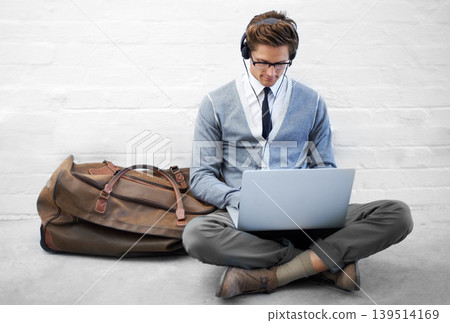 Business man, reading or luggage with laptop, floor and music with app, flight or travel by wall background. Entrepreneur, person or employee with headphones, computer or audio streaming subscription Business man, reading or luggage with laptop, floor and music with app, flight or travel by wall background. Entrepreneur, person or employee with headphones, computer or audio streaming subscription 139514169