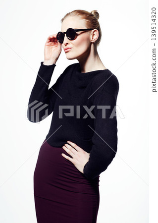Woman, sunglasses for beauty or fashion, cosmetic care and wellness with protection from sun on white background. Black eyewear, casual clothes and pose in studio with makeup, eye care and confidence Woman, sunglasses for beauty or fashion, cosmetic care and wellness with protection from sun on white background. Black eyewear, casual clothes and pose in studio with makeup, eye care and confidence 139514320
