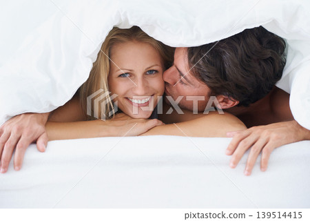 Covers, portrait or happy couple kiss in bed on holiday vacation or romantic honeymoon in marriage. Morning, love or people with smile or joy in home, house or hotel together with duvet, bond or care Covers, portrait or happy couple kiss in bed on holiday vacation or romantic honeymoon in marriage. Morning, love or people with smile or joy in home, house or hotel together with duvet, bond or care 139514415