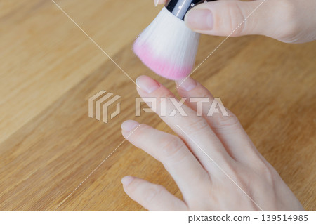 一位女士正在用除塵刷清除指甲縫裡的灰塵。 一位女士正在用除塵刷清除指甲縫裡的灰塵。 139514985