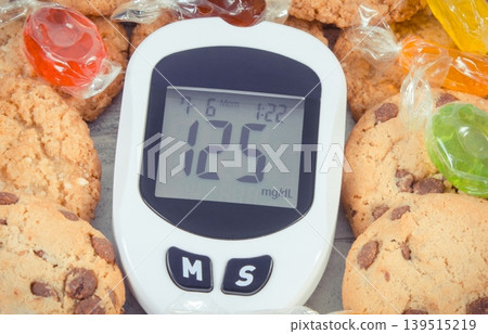 Glucometer with high sugar level, candies and cookies 139515219